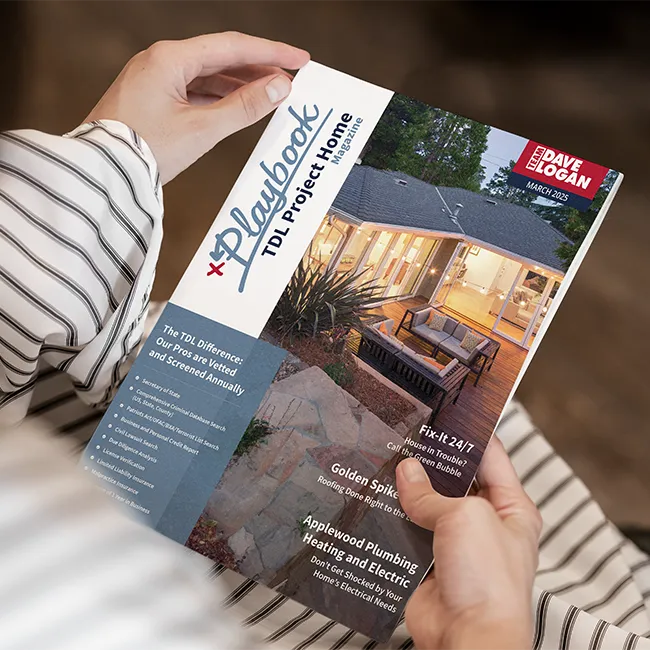 Close up of hands holding a magazine of the Playbook Project Homes in their lap
