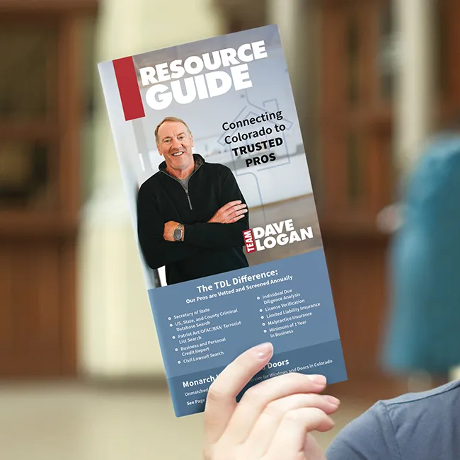 A hand holding a trifold brochure with a Team Dave Logan Resource Guide cover
